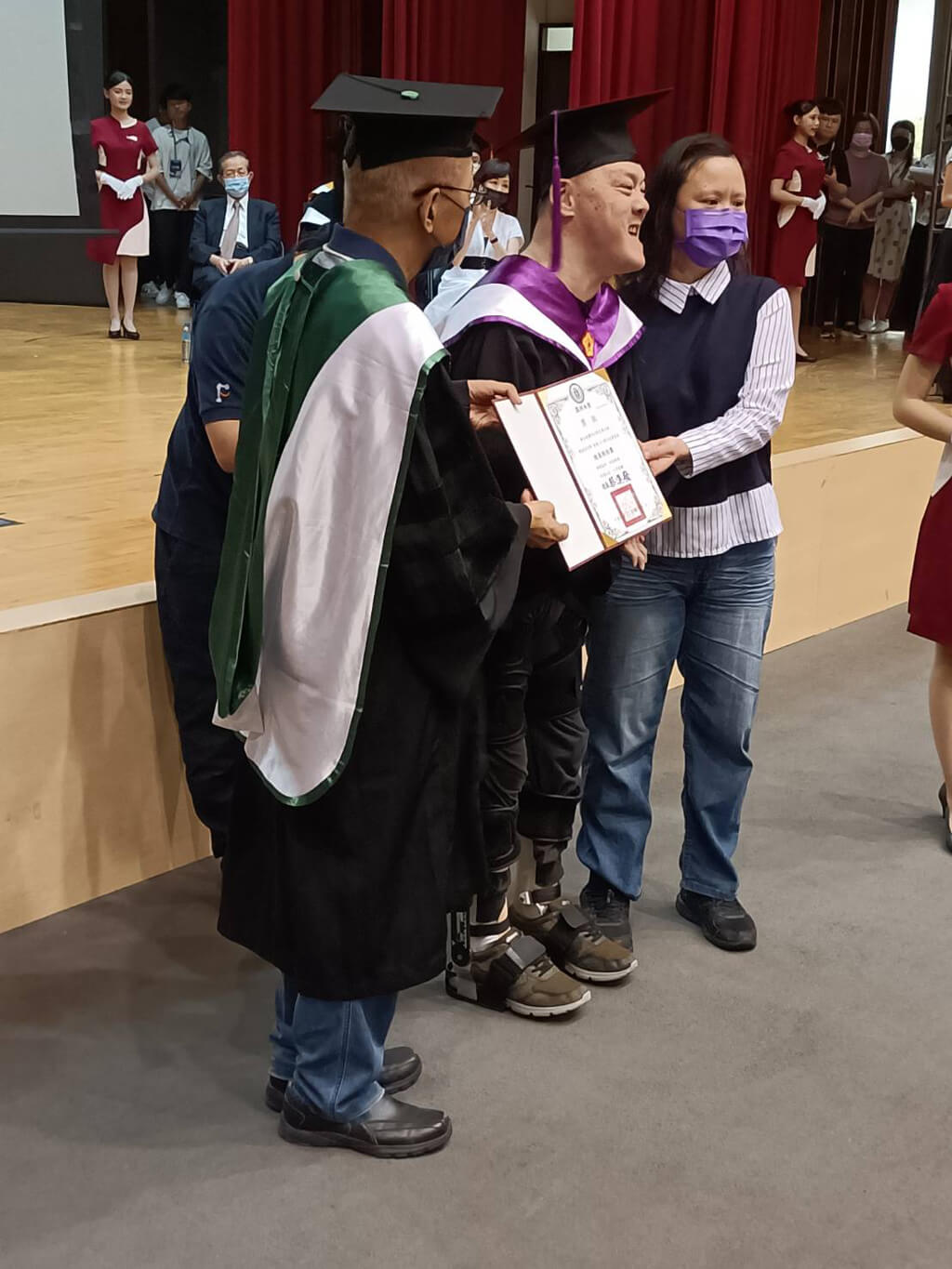 借助福寶科技外骨骼機器人輔助行走，亞洲大學行動不便博士生親自步入畢業典禮會場，完成領證時刻。